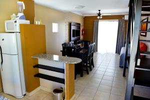 a kitchen and dining room with a counter and a refrigerator at Complejo Pircas Mar in Las Grutas
