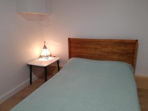 a bedroom with a bed and a table with a lamp at The House On The Lake in Ferme-Neuve