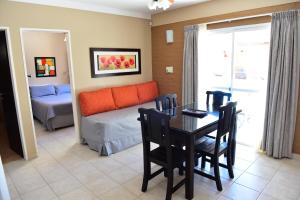a living room with a table and a couch at Complejo Pircas Mar in Las Grutas