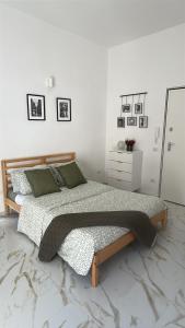 a bedroom with a bed and a white wall at Dimora San Mario in Portici