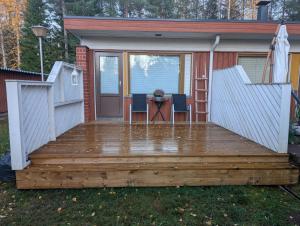 a deck with a table and chairs on a house at Mäntypää, keskellä Vuokattia in Vuokatti