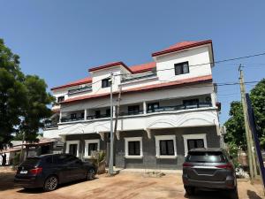 two cars parked in front of a building at FassoImmoPrestige 