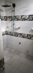 a bathroom with a shower with white tile floors at FassoImmoPrestige 