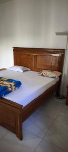 a bed with a wooden headboard and pillows on it at FassoImmoPrestige 