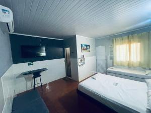 a bedroom with a bed and a sink in it at Hotel Morada da Serra in Macacos