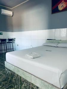 a large white bed in a room with chairs at Hotel Morada da Serra in Macacos