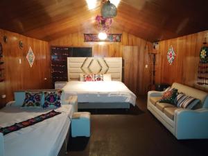 a bedroom with a bed and two couches in it at Uros encantos del titikaka lodge in Puno