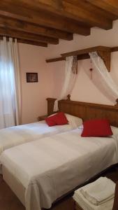 two beds in a bedroom with white and red pillows at B&B Villa Ca'Praja in Daone