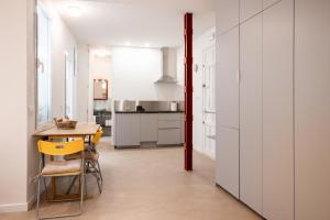マドリードにあるPremium loft in the center of Madrid, Casa Garcíaの白い壁のキッチン(テーブル、椅子付)