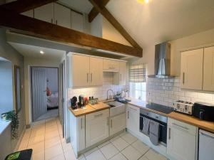 a kitchen with white cabinets and white appliances at The Annexe in Newark-on-Trent
