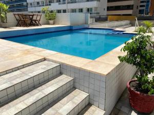 a swimming pool with blue water in a building at Beira-Mar Flat Venetto - Premium in Fortaleza