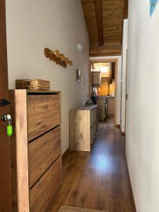 a hallway leading to a kitchen with wooden floors and a door at Panoramic attic in Temù in Temù +4 photos