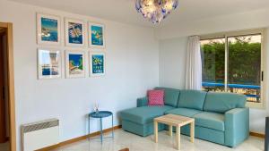 a living room with a blue couch and a table at Beach and Sea View in Roquebrune-Cap-Martin +11 photos