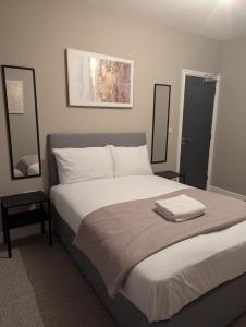 a bedroom with a large bed with two mirrors at Comfy Stays Newcastle in Newcastle upon Tyne