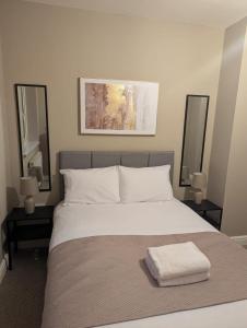 a bedroom with a large white bed with two mirrors at Comfy Stays Newcastle in Newcastle upon Tyne +5 photos