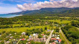 an aerial view of a village with the ocean and mountains at Cabinas Bahía Uvita - Marino Ballena National Park Lodge in Uvita