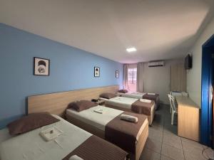 a hotel room with four beds and a room with at Executivo Prime Hotel in Teresina