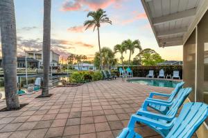 un patio con sillas azules y una piscina en Sand Dollar Cottage - 910, en Siesta Key