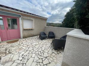 a patio with two chairs and a pink door at Maison n2 Donasete T1 in Vieille-Brioude