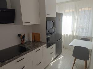 a kitchen with white cabinets and stainless steel appliances at 2-room apartment, central & quiet in Gdynia