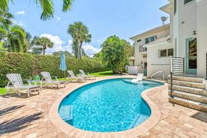 a swimming pool with chairs and a house at The Sun Dial - 827 in Siesta Key