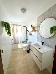 a bathroom with a sink and a toilet and a mirror at Casa Margarita in San Pedro del Pinatar