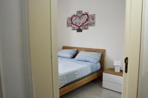 a bedroom with a bed with a picture on the wall at Adriatic Suite - Casa vacanze nel Salento in SantʼAndrea