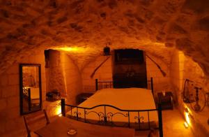 a bedroom in a cave with a bed in it at Emka historic biutuque stone house in Urfa +4 photos