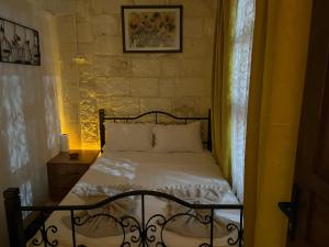 a small bedroom with a bed with a window at Emka historic biutuque stone house in Urfa