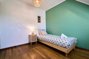 a bedroom with a bed and a blue wall at La Halte Verte - Garden -Wifi - Near Lille in Ennevelin +31 photos