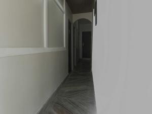 a hallway with white walls and wooden floors at Collection O Police Bazar Shillong Formerly Pillars House in Shillong +61 photos