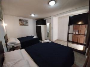 a small room with two beds and a window at Hotel Las Gardenias in Cataltzul