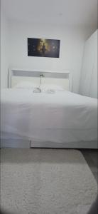 1 cama blanca en un dormitorio con una foto en la pared en Luxury Oaks Apartment, en Flic en Flac 23 fotos más