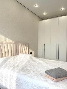 a bedroom with a white bed and white cabinets at Жилой комплекс Космос in Bishkek