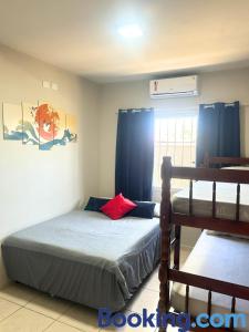 a bedroom with a bed and a window with blue curtains at Casa Sol da Manhã - Piscina aquecida com hidromassagem - 300m da praia in Guaratuba +48 photos