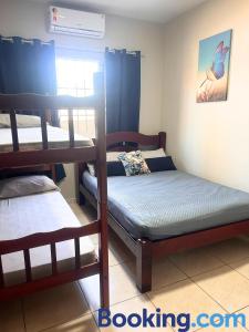 a bedroom with two bunk beds in a room at Casa Sol da Manhã - Piscina aquecida com hidromassagem - 300m da praia in Guaratuba