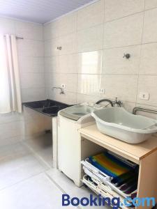 a bathroom with a sink and a bath tub at Casa Sol da Manhã - Piscina aquecida com hidromassagem - 300m da praia in Guaratuba