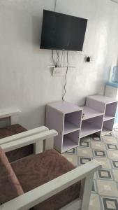 a bedroom with a desk and a tv on a wall at Savannah Apartments in Narok
