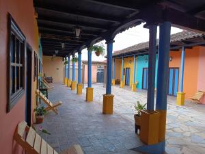 a hallway of a building with blue columns and benches at Jazmin Hotel Boutique Colonial in Comitán de Domínguez
