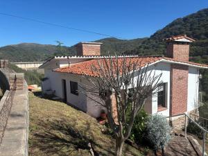 ein kleines weißes Haus mit einem Berg im Hintergrund in der Unterkunft Alquiler en La Quebrada Rio Ceballos Córdoba in Río Ceballos