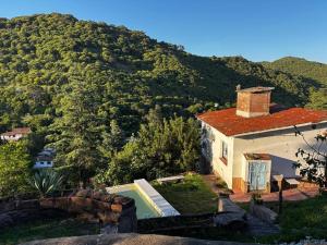 ein kleines Haus mit einem Berg im Hintergrund in der Unterkunft Alquiler en La Quebrada Rio Ceballos Córdoba in Río Ceballos