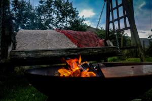 a fire pit with a bed on a swing at Nant Cafn - Hafan Hideaways Eryri in Machynlleth