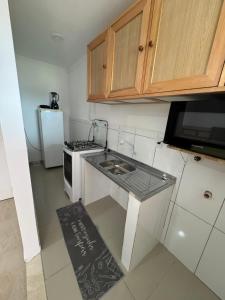 a small kitchen with a stove and a refrigerator at Brenda Eduarda in Balneário Camboriú
