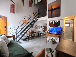 ein Wohnzimmer mit einer Wendeltreppe und einem Wohnzimmer in der Unterkunft Loft do Fotógrafo 1 - Ao lado do Rio das Almas in Pirenópolis