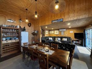 a kitchen and dining room with a table and a couch at Motutangi Heights in Pukenui