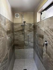a bathroom with a shower with a glass door at Motutangi Heights in Pukenui