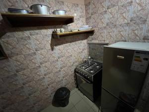 a small kitchen with a stove and a refrigerator at Elzo Crib !!! in Dakar
