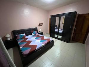 a bedroom with a large bed and a mirror at Elzo Crib !!! in Dakar