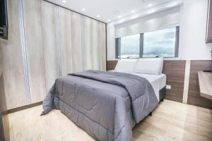 a bedroom on a yacht with a bed and a window at Apto de 2 Quartos no 35 andar c 2 Vagas - SEV3507 in Curitiba