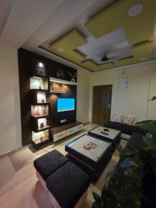 a living room with couches and a flat screen tv at Shivalay - By Safarnama Stays - Near Kashi Vishwanath in Varanasi